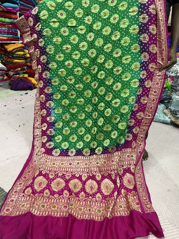 A bandhani dupatta held open in a Nai Sarak textile shop