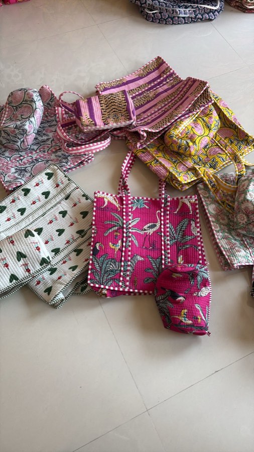 Hand-block-printed bags and purses laid out at a stall