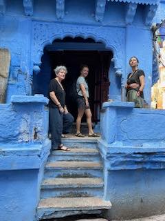 Three guests in a carved blue doorway